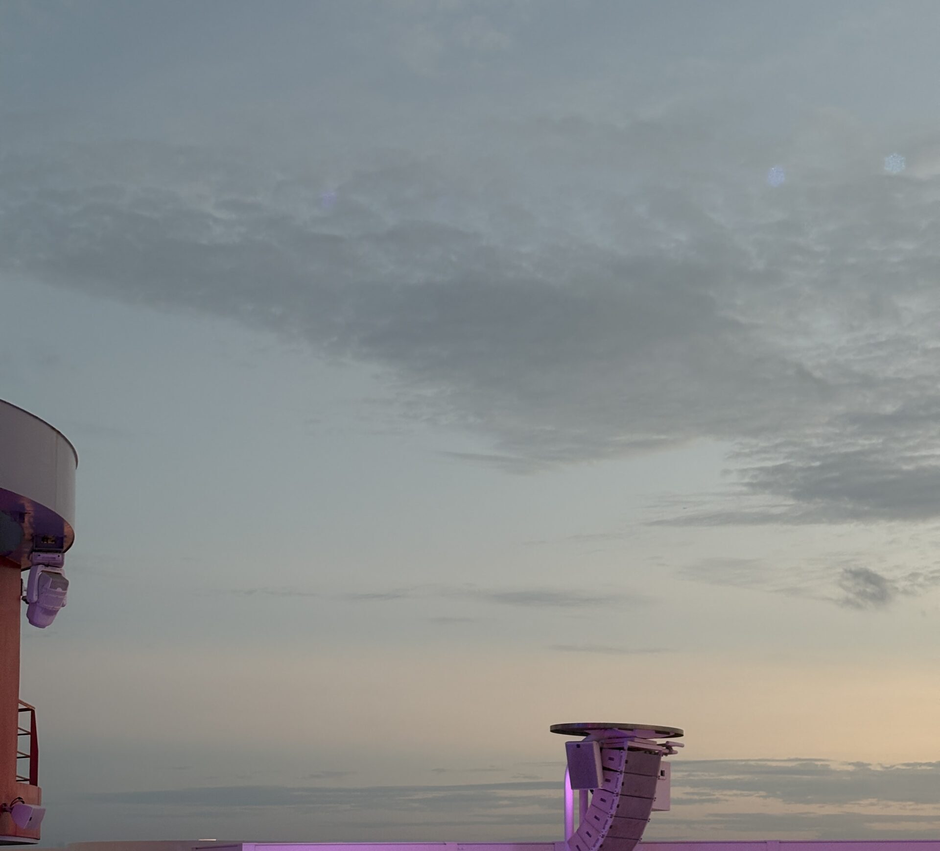 Elegant luxury cruise ship sailing at sunset with guests enjoying outdoor decks and amenities