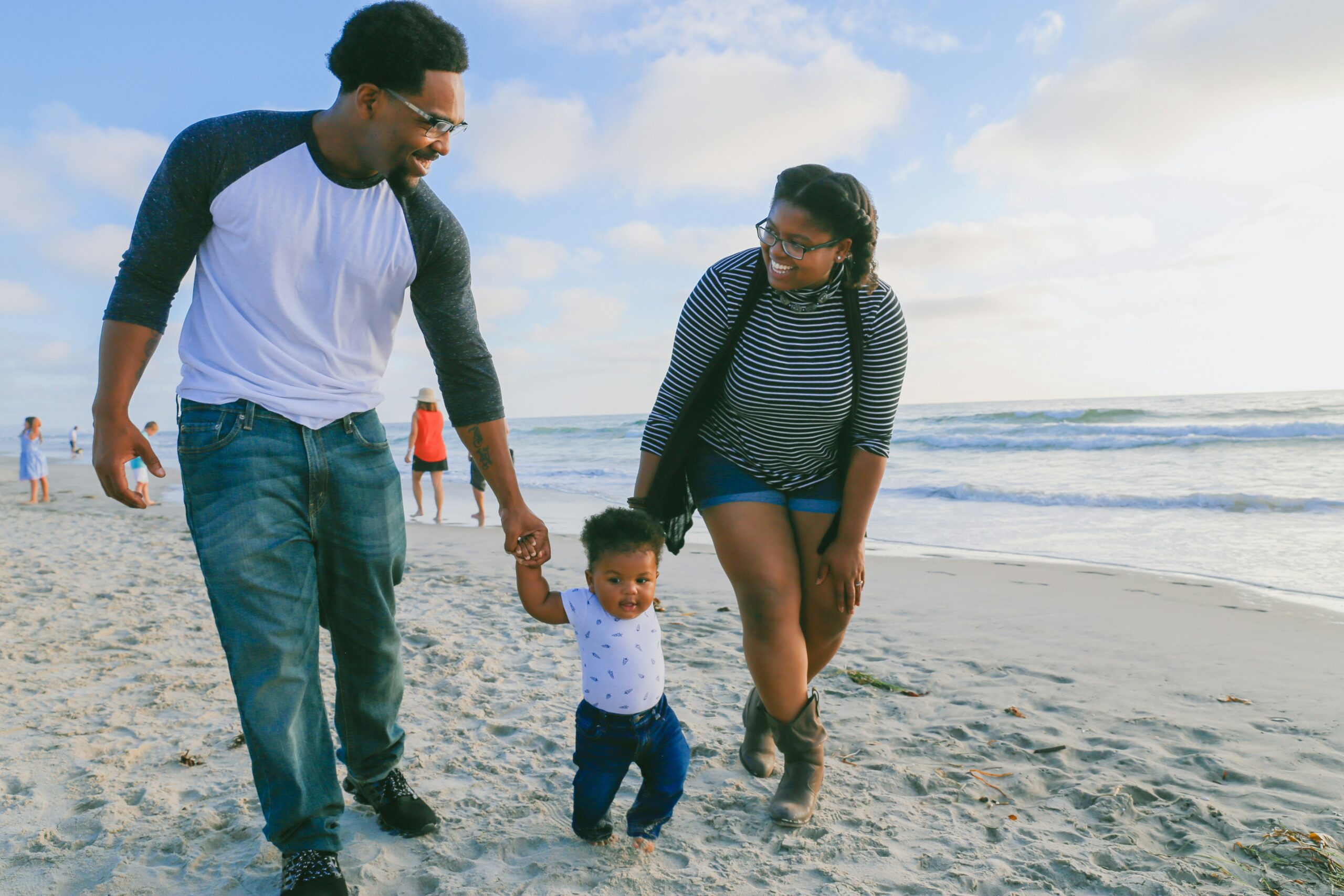 Multigenerational family smiling and embracing on a beach