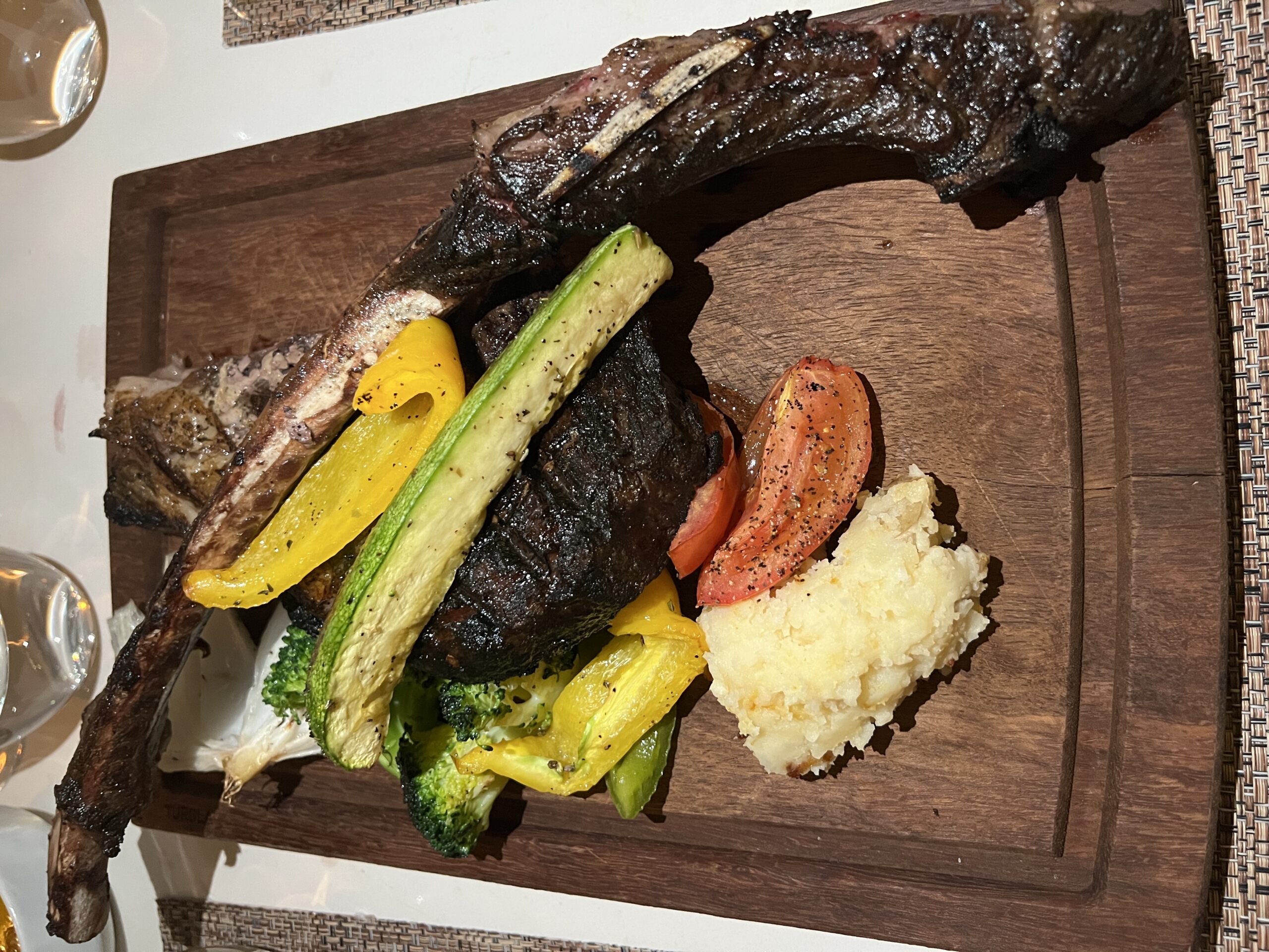 Romantic candlelit table setting with wine glasses and fine china in Paris restaurant.