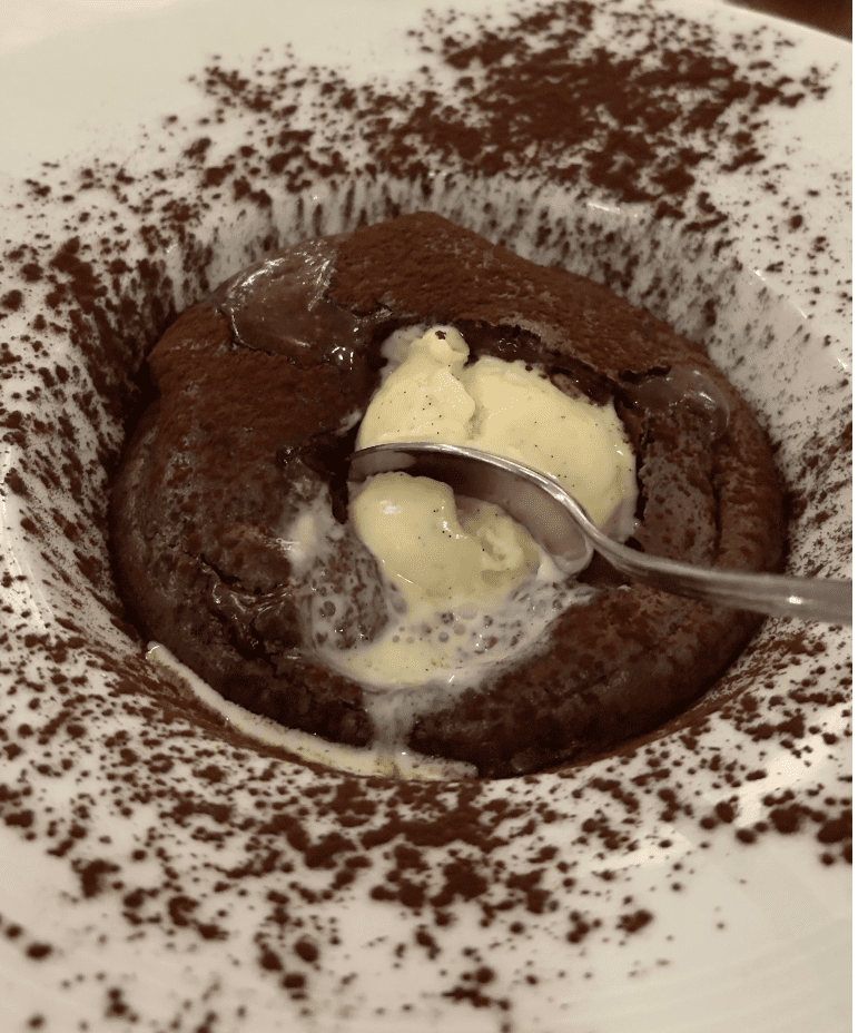 Molten chocolate lava cake with berries served at Michelin-starred Paris restaurant.