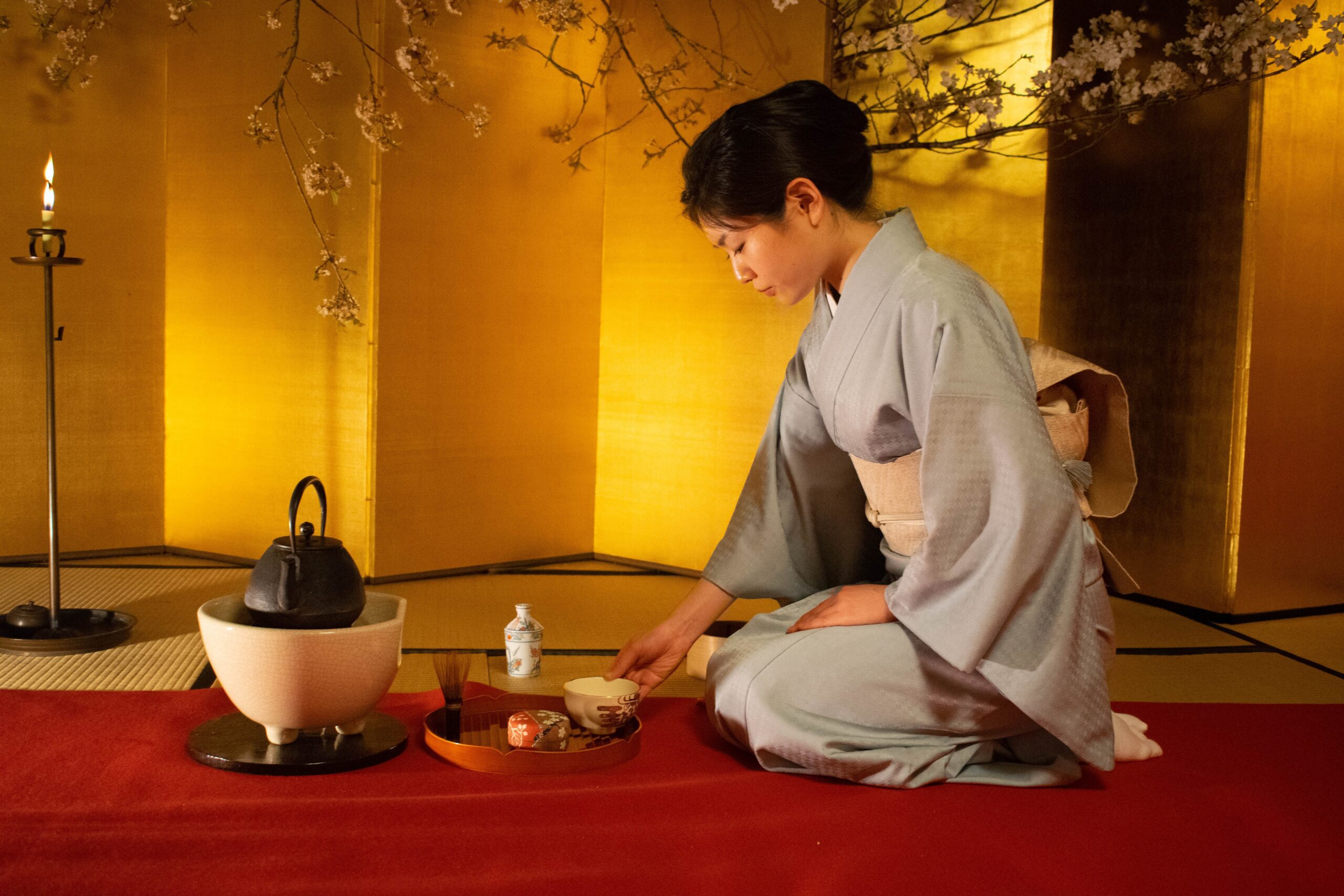 Alt text: Japanese tea master performing traditional tea ceremony in Kyoto tea house.