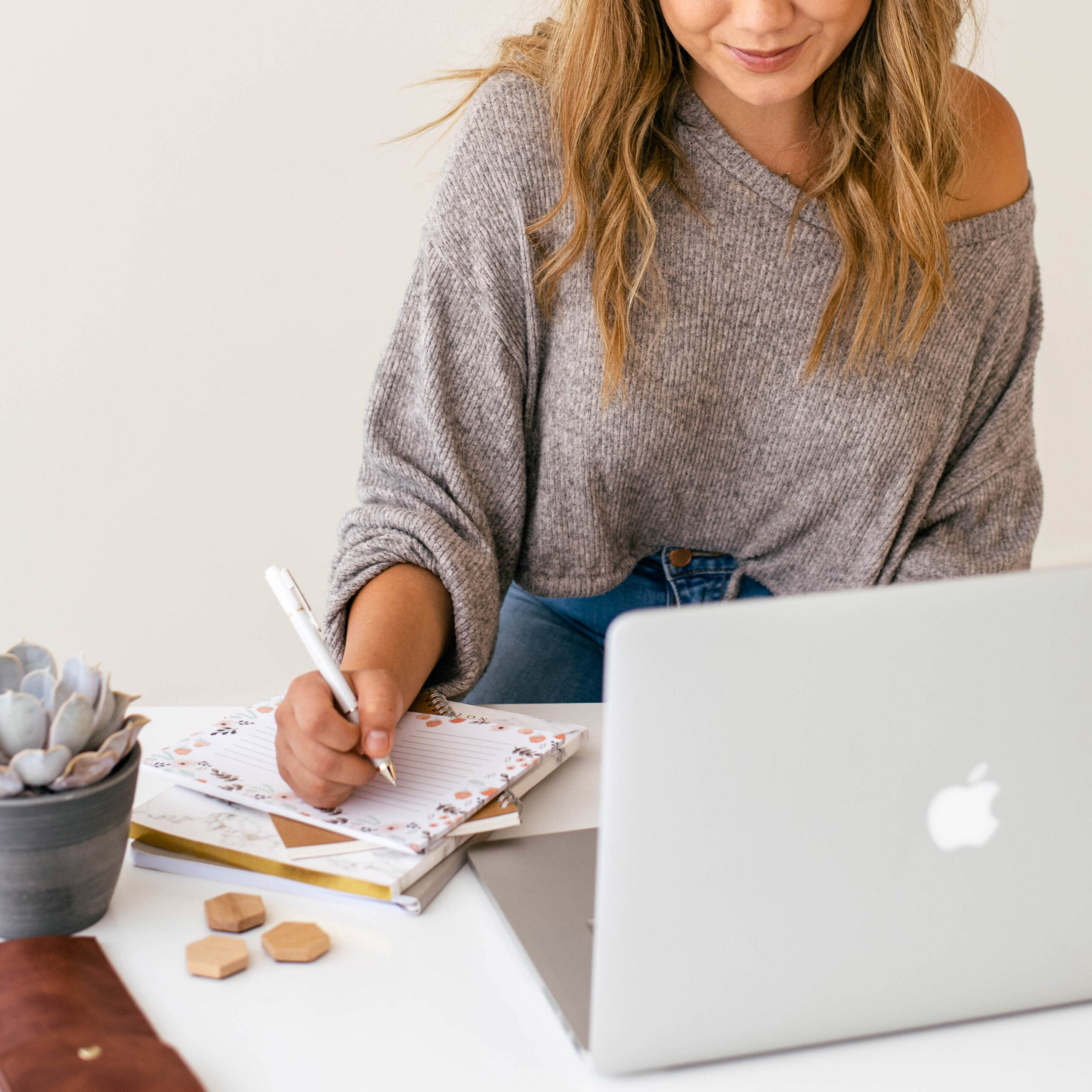 Woman planning a set-jetting trip on laptop with travel inspiration notes